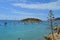 Panoramic seascape : beach with palette of blue, boats and small islet. Mallorca, Spain