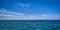 Panoramic seascape on a bright summer day with few sailing boats afar, great sky with beautiful clouds. Peaceful