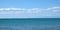 Panoramic seascape with sea surface and high mountains silhouettes