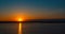 Panoramic seashore view with dramatic golden sunset. Calm beach in background.