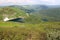 Panoramic shot of an alpine valley with many lakes and the remains of snow on the slope