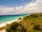 Panoramic shot of clear water of the sea on a white-sand shoreline