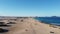 Panoramic shot of an empty lonely sandy beach with small bushes at the Atlantic Ocean in the soft morning light, flying