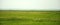 Panoramic shot of endless steppe flooded with soft sunlight