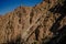 Panoramic shot f a bare mountain with small soil erosion against a clear blue sky