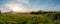 Panoramic shot of farmland with overlook to mountains during a sunny day