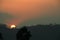 Panoramic shot of the golden sun at sunset disappearing behind the mountains