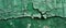 A panoramic shot of a green painted wall with extensive cracking and flaking, depicting the beauty of decay and the