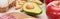 Panoramic shot of half of avocado on marble surface near peanuts, apple and part of egg.