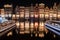 Panoramic shot of the illuminated colorful buildings along Canal Singel at night