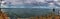 Panoramic shot of the ocean under the cloudy and rainy sky