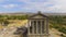 Panoramic shot of old Garni temple overlooking mountains and village in Armenia
