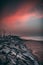 Panoramic shot of rocks piled into the side of a shore on an indigo sky background