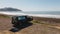 Panoramic shot of the sea with a campervan on the beach under the clear sky, New Zealand