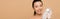 Panoramic shot of smiling nude asian girl in latex gloves holding glass container with face cream