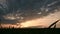 Panoramic Silhouette of a green wheat field against the backdrop of the setting sun and an epic sky with sunset clouds