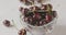 Panoramic slow motion close-up of a sweet ripe red cherry in a glass bowl on a white table and blurred background of