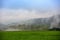 Panoramic spring landscape with a wide view over fields, forest, hills and foggy valleys towards the horizon