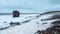 Panoramic stormy landscape with white sea foam on the shore, a thrown tree and a large rock sticking out of the water