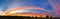 Panoramic striking sunset background with vivid orange, blue, red and yellow, in the shape of a rainbow.