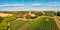 Panoramic summer view from flying drone of Pomposa Abbey tower among the green vineyards.