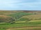 A panoramic sunlit pennine landscape with small valleys between rolling hills with typical yorkshire dales stone walls and farmhou