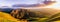 Panoramic sunset view of hills and valleys in the Diablo mountain range starting to turn green; San Jose and bright light from the