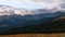 Panoramic time lapse of clouds moving above mountain peaks at sunset