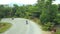 Panoramic top view of the jungle in Phuket, Thailand. The drone goes down to the road, where you can see moving motobikes, forest