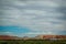 Panoramic of Train on tracks in southwestern United States with badlands and cliffs in the background