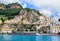 Panoramic view, aerial skyline of small haven of Amalfi village with tiny beach and colorful houses located on rock. Tops of