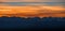 Panoramic view of alpine snowcapped mountain peaks at sunset.