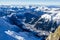 Panoramic view of Alps and french town Chamonix-Mont-Blanc. All around there are summits of Alps and rocks covered with snow.