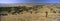 Panoramic view as Masai Warrior in red surveying landscape of Lewa Conservancy, Kenya, Africa with Mount Kenya
