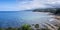 Panoramic view of the Asturian coast viewed from Lastres, with white sandy beaches mixed with green mountains and a blue sky with