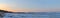 Panoramic view of the bank of the Volga River, covered with ice and the Zhiguli Mountains at sunrise.