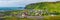 Panoramic view of basalt stacks Reynisdrangar, black sand beach, church and city of Vik at South Iceland, summer time