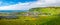 Panoramic view of basalt stacks Reynisdrangar, black sand beach, church and city of Vik at South Iceland, summer time