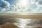 Panoramic view of the beach and the mud flat sea with a watercourse