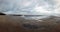 Panoramic view of the beach at sandsend near whitby at low tide with a dramatic stormy cloudy sky reflected in pools of water