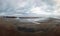 Panoramic view of the beach at sandsend near whitby at low tide with a dramatic stormy cloudy sky reflected in pools of water