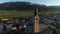 Panoramic view of beautiful landscape of small spring town among Austrian alpine mountains. Drone video of church and