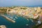 Panoramic view of beautiful Procida in sunny summer day. Colorful houses, cafes and restaurants, fishing boats and yachts in