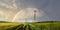 Panoramic view of beautiful Russian landscape. Double rainbow over green wheat fields and power lines