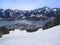 Panoramic view of beautiful winter scenery in the Alps with clear lake, snow slopes, cable car ski lift cabins and