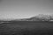 Panoramic view from boat on Tromso landscape with snowy mountains and city harbor in black and white, Norway