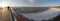 Panoramic view of bridge, sandy beach under snow and ice waves of the Baltic Sea on a sunny day in Palanga, Lithuania