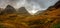 Panoramic view of bright green and orange mountains on an overcast afternoon in Glencoe, Highland, Scotland, UK