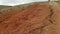 Panoramic view of the bright hills of Kyzyl Chyna in the Altai Republic in Russia. Bright red earth and cracks in it. Dry weather