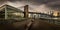 Panoramic view of Brooklyn Bridge against skyscrapers of New York on a gloomy day